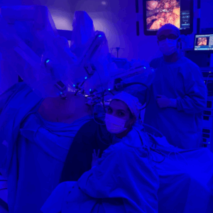Médico cirurgião controlando braços de um robô durante uma cirurgia digital minimamente invasiva.