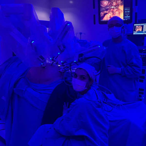 Médico cirurgião controlando braços de um robô durante uma cirurgia digital minimamente invasiva.